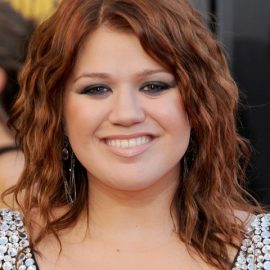 Kelly Clarkson shoulder length copper hairstyle with tousled waves