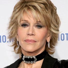 Jane Fonda medium layered blonde messy hairstyle with bangs for older women over 60